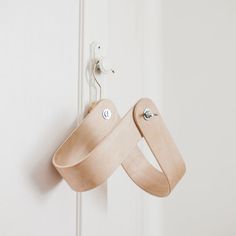 a wooden object hanging on the side of a door with two hooks attached to it