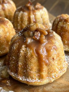 some kind of pastry with nuts on it sitting on top of a wooden table next to other pastries