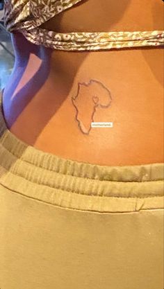 a woman with a small tattoo on her lower back and the word africa written in it