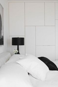 a bed with white sheets and black pillows