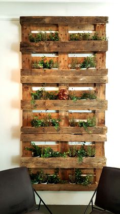 two chairs sitting next to each other in front of a wall mounted planter