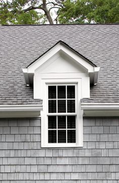 a white window sitting on the side of a gray building