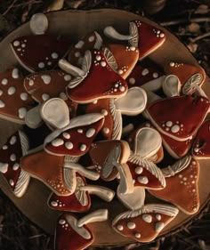 decorated cookies in the shape of hearts on a wooden platter with leaves and twigs