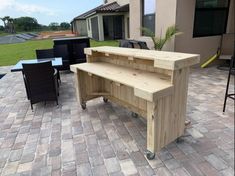 a wooden bench sitting on top of a brick patio next to a table and chairs