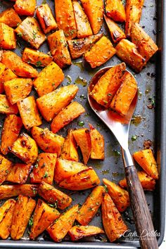 roasted sweet potatoes on a baking sheet with a spoon