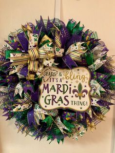 a mardi gras wreath hanging on a door with the words it's a blessing