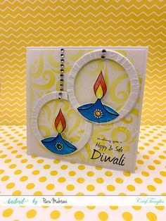 a card with two candles on it and the words happy diwali written in blue