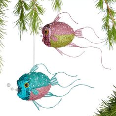 two fish ornaments hanging from a christmas tree