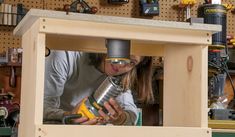 a woman is working on a project in a workshop with tools and woodworking equipment