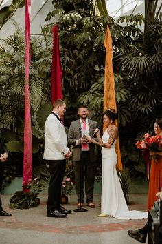 a man and woman are getting married in a greenhouse