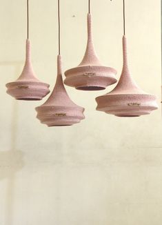 four pink lamps hanging from the ceiling in a room