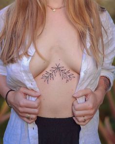 a close up of a woman with tattoos on her chest