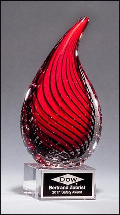 a red glass award sitting on top of a table