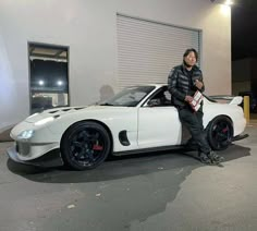 a man standing next to a white sports car