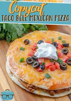 the mexican pizza is topped with cheese and black olives, sour cream on top