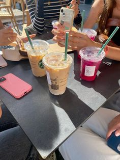 people sitting at a table with drinks and cell phones