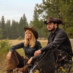 a man and woman are sitting in the grass