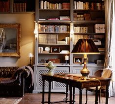 a living room filled with furniture and bookshelves covered in lots of bookcases