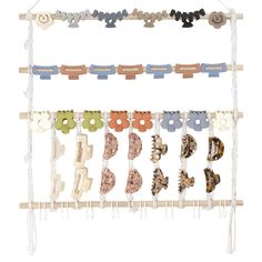 an assortment of different types of hair clips hanging from a clothes line on a white background