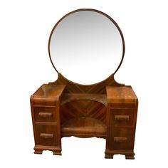 an antique wooden vanity with a round mirror on it's top shelf and drawers