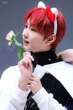 a person with red hair holding a rose