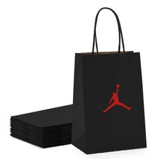 a black shopping bag with a red jordan logo on the front and six smaller bags stacked next to it