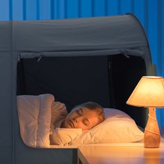 a woman laying in bed under a tent