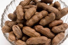 peanuts in a glass bowl on a white surface