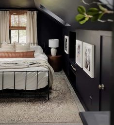 an attic bedroom with black walls and white bedding