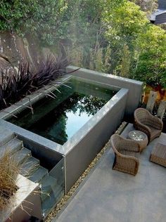 an outdoor garden with a pond and seating area