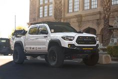 a white truck parked in front of a large building