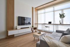 a living room filled with furniture and a flat screen tv on top of a wooden shelf