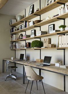 a laptop computer sitting on top of a wooden desk in front of a bookshelf