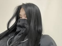 a woman with long black hair wearing a jacket