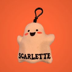 a white stuffed ghost hanging on an orange background