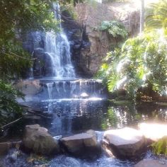 there is a waterfall and some rocks in the water