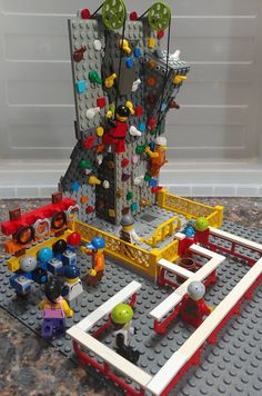 a lego model with people and buildings on it's surface, including a building made out of legos