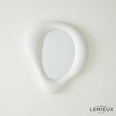 an oval shaped mirror on a white background with the word lemieux written below it