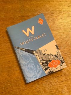 the book w is for whitstable sits on top of a wooden table