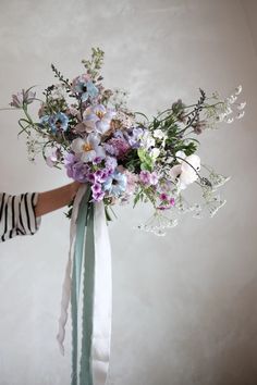 a woman holding a bouquet of flowers in her hands