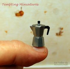 a tiny stove sitting on top of a persons finger