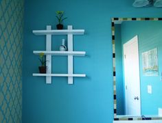 a bathroom with blue walls and white shelving on the wall next to a sink