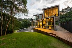 a modern house in the middle of a lush green field with stairs leading up to it