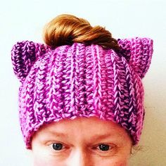 a woman wearing a purple knitted hat with ears