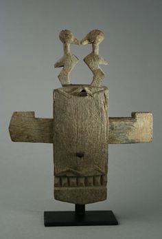 a wooden sculpture with two people standing on top of it