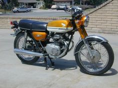 an orange and black motorcycle parked in a parking lot