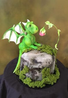 a green dragon sitting on top of a tree stump