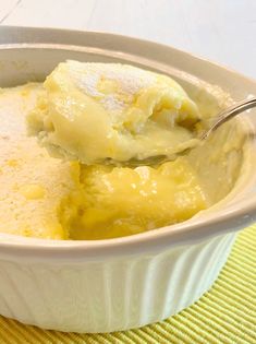 a white bowl filled with food on top of a yellow place mat next to a spoon