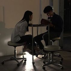 two people sitting at a table in the dark