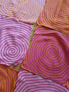 crocheted placemats are arranged on the floor in different colors and patterns